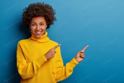 cheerful young woman yellow sweater points aside crc8acb413f size16.99mb 8495x5663 - title:graphic home - اورچین فایل - format: - sku: - keywords: p_id:353984