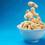 falling cashew nuts into bowl blue background wit crcab3a4db9 size10.95mb 5000x3342 - title:Home - اورچین فایل - format: - sku: - keywords:وکتور,موکاپ,افکت متنی,پروژه افترافکت p_id:63922
