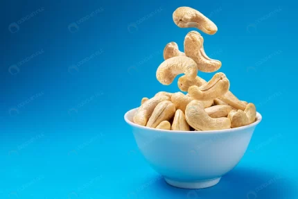 falling cashew nuts into bowl blue background wit crcab3a4db9 size10.95mb 5000x3342 - title:graphic home - اورچین فایل - format: - sku: - keywords: p_id:353984