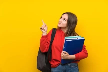 teenager student girl yellow wall pointing with index finger great idea - title:graphic home - اورچین فایل - format: - sku: - keywords: p_id:353984