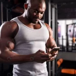 young male athlete uses phone during workout gym rnd143 frp22364222 - title:Home - اورچین فایل - format: - sku: - keywords:وکتور,موکاپ,افکت متنی,پروژه افترافکت p_id:63922
